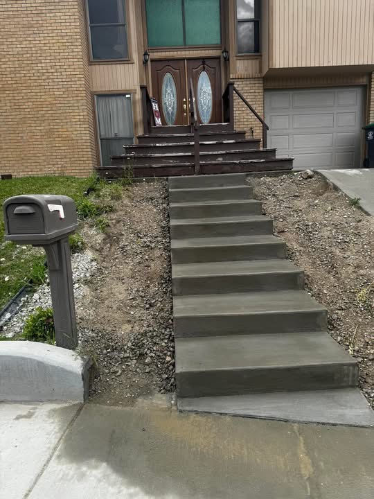Newly poured concrete entry steps leading up to a residential front door.