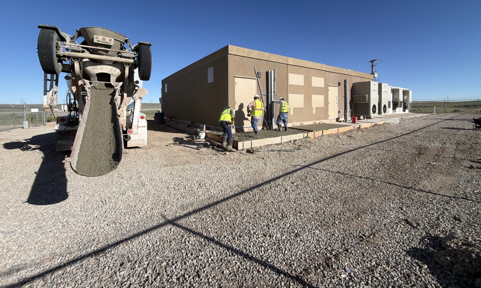 JJJ Construction crew placing concrete alongside a facility building outside Rock Springs, Wyoming