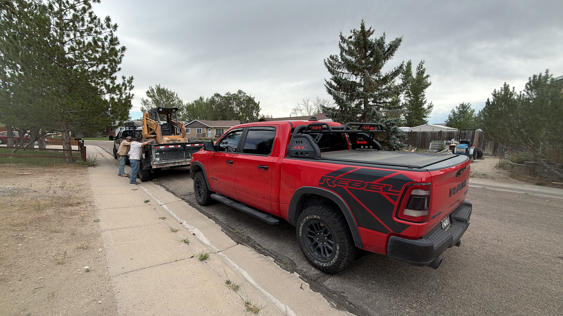 JJJ crew securing a skid steer on a trailer before heading to a job site.