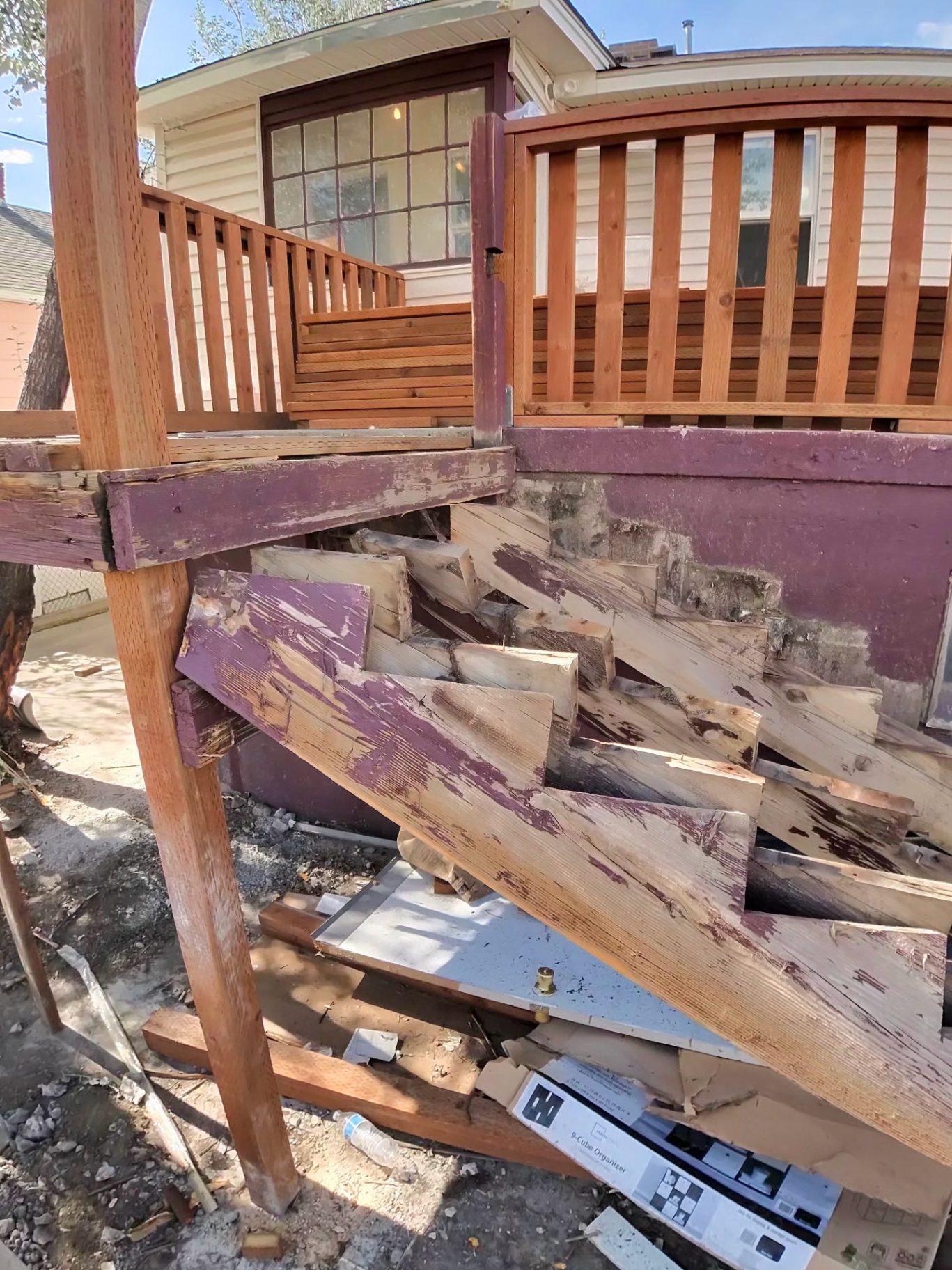 Old painted deck stair framing removed and stacked during tear-out.