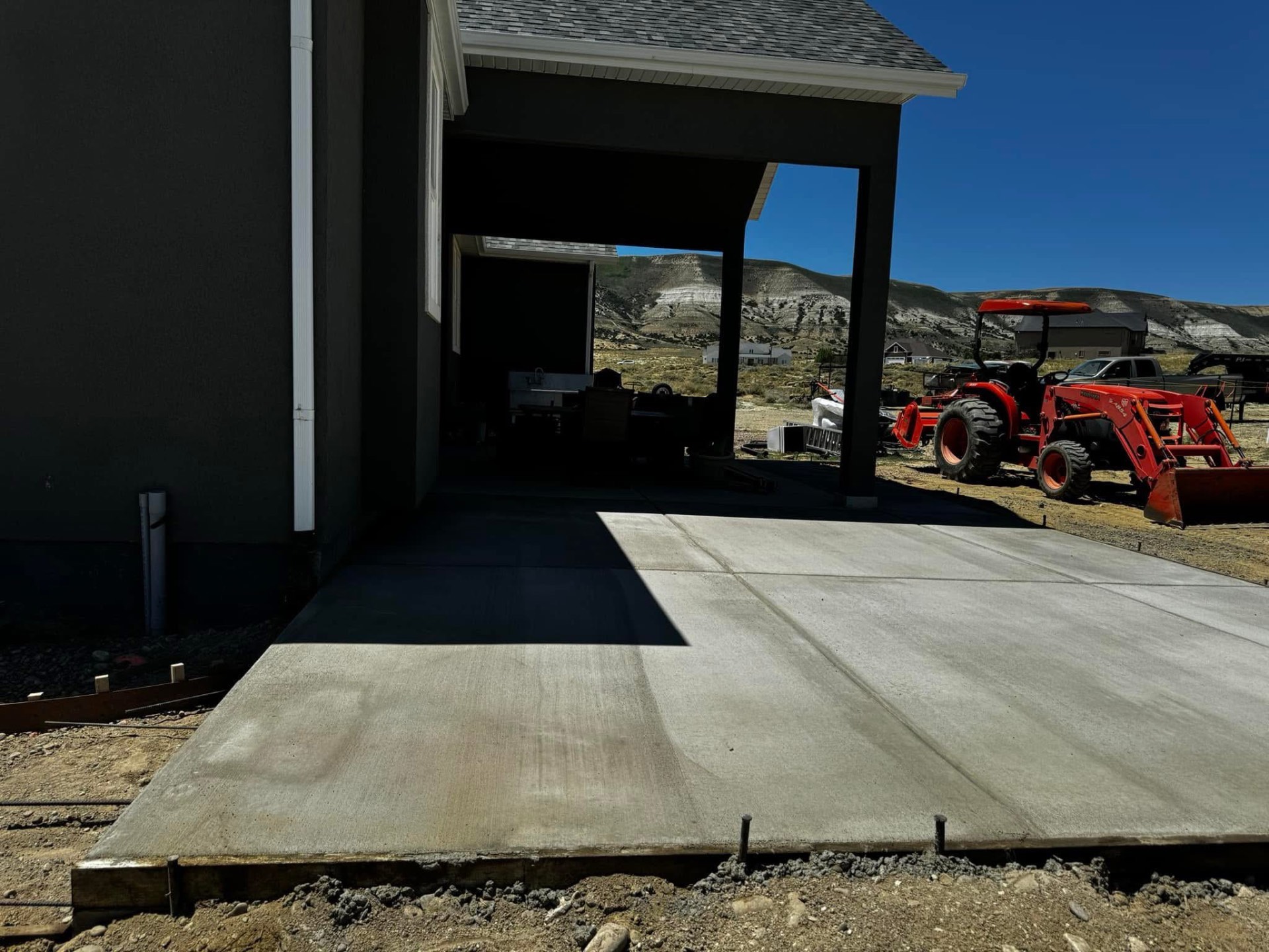 Finished residential concrete driveway slab leading to a covered garage entry.