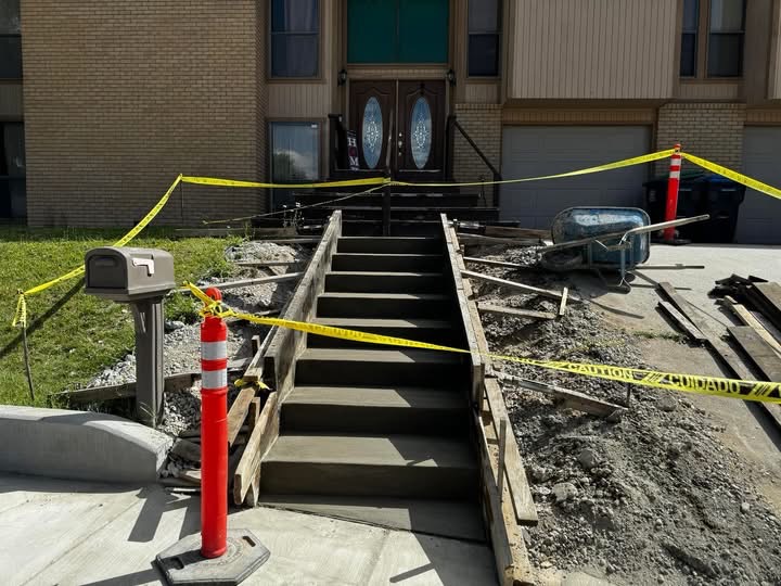 Front entry steps braced and formed after demolition, with the work area taped off.