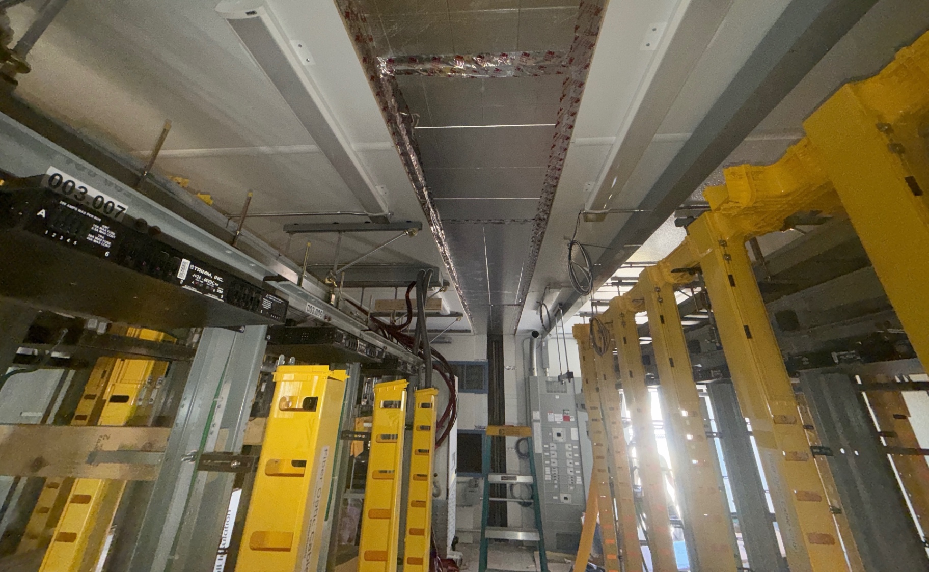 Facility interior during general construction support, with equipment racks and cable systems installed by other trades visible in place.