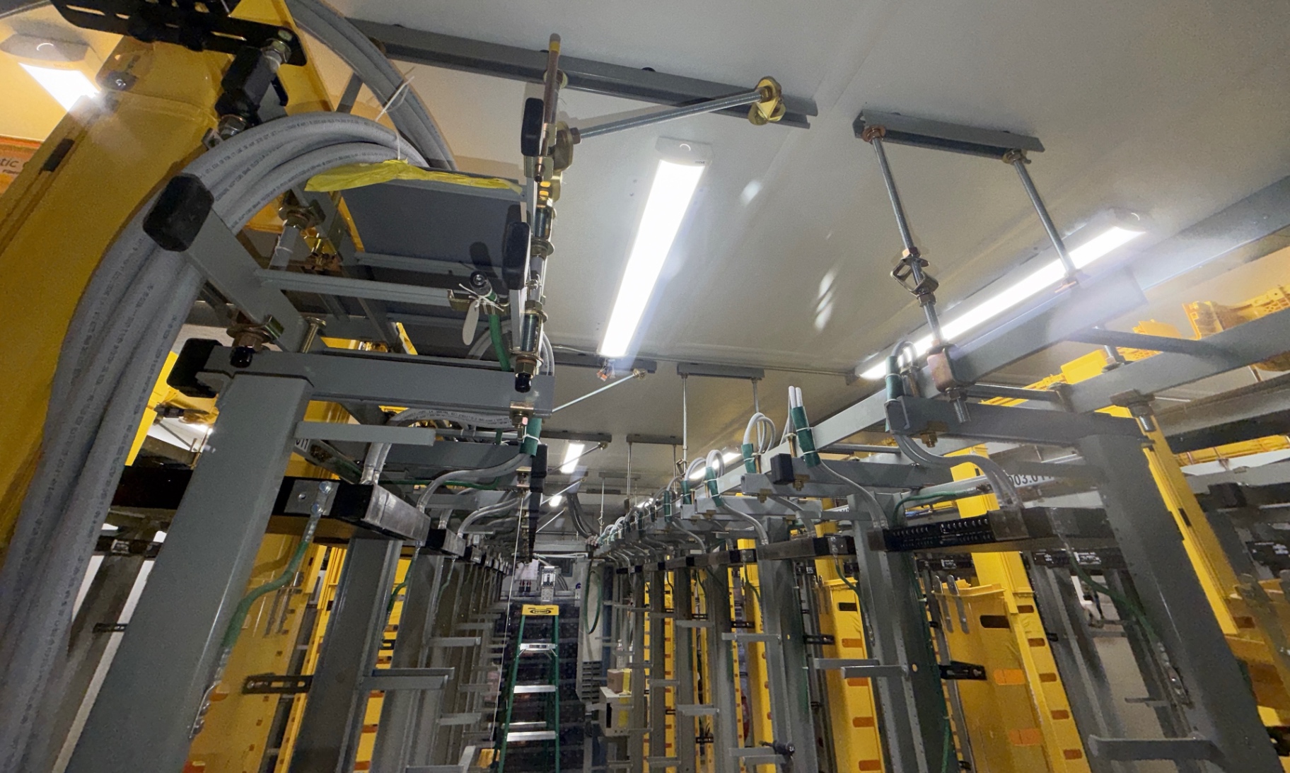 Facility overhead framing and construction support, with equipment systems installed by other trades visible below.