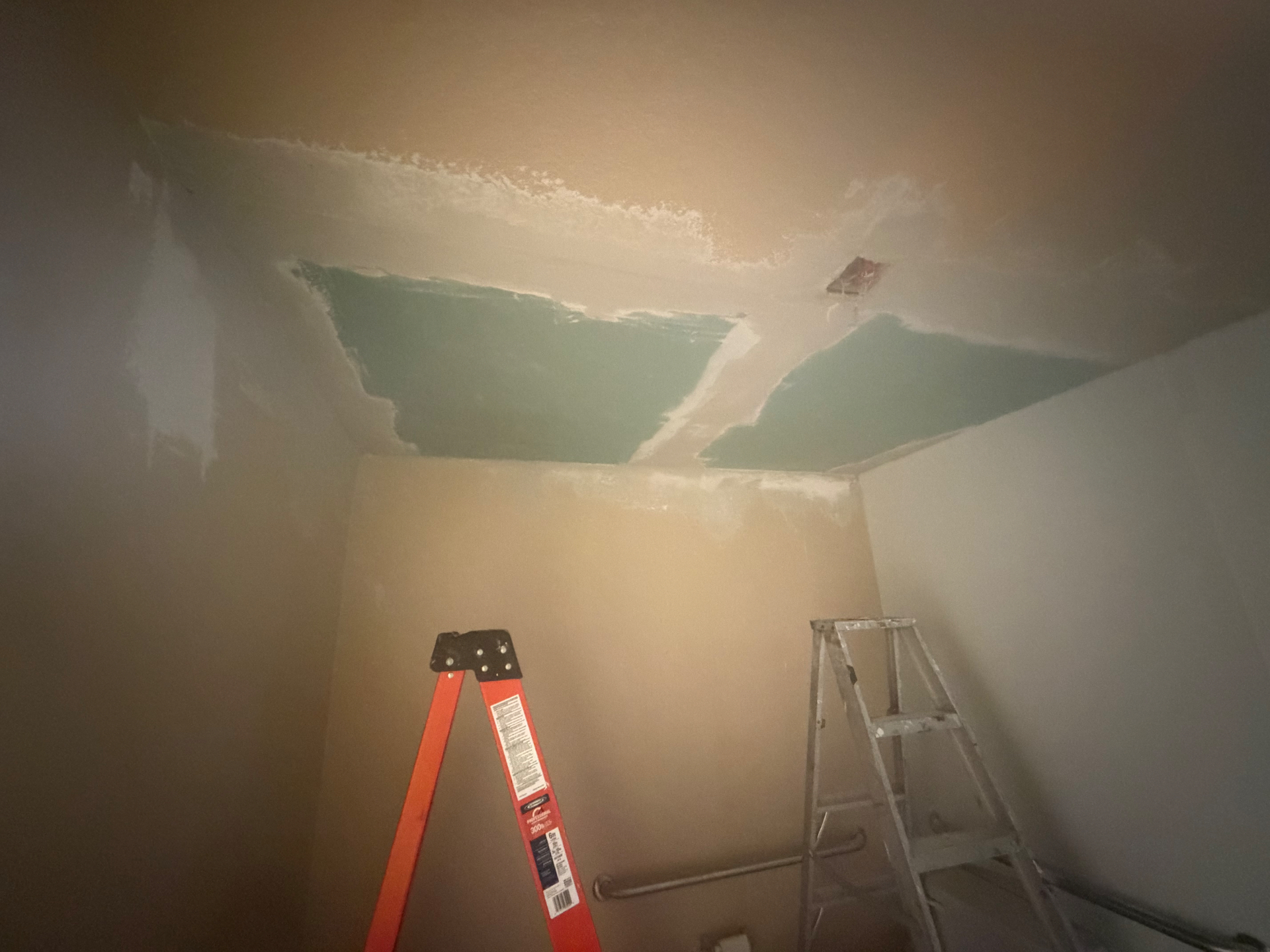 Ceiling drywall patch taped and coated with joint compound before finish.