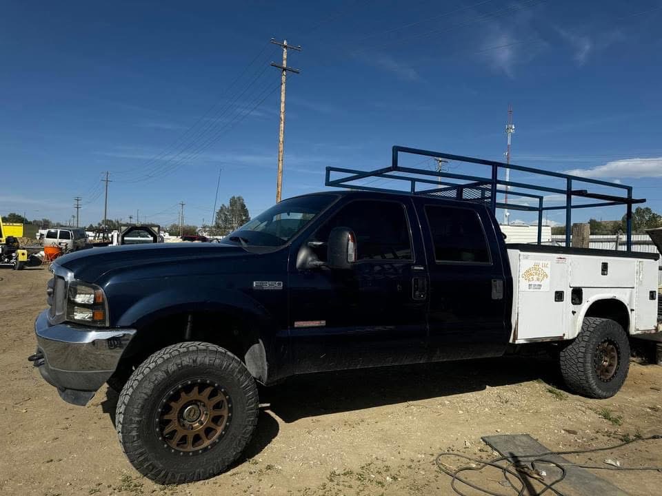 JJJ Construction service truck with material rack parked at the company yard.